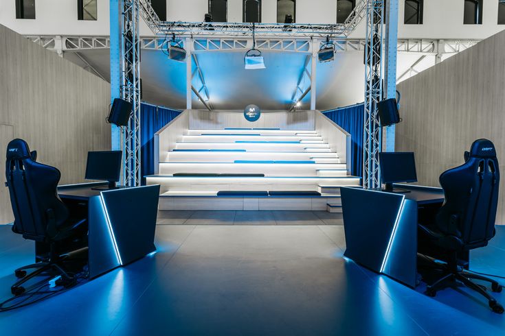 A modern collaborative eSports training facility filled with premium screens showing performance graphing tools